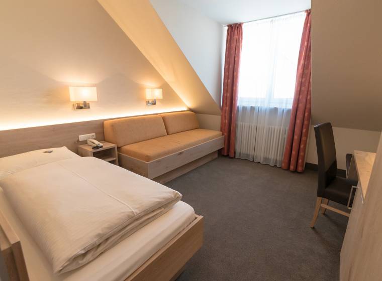 Einzelzimmer mit Sofa und Schreibtisch Hotel Lutter in München